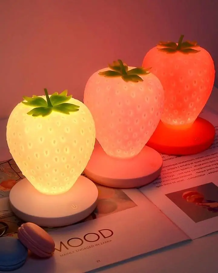 Glowing strawberry LED night lights from The Other Aesthetic creating ambient bedroom lighting with colorful millennium-inspired vibes.