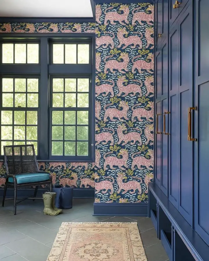 Navy statement wall with coral tiger pattern from @shoppehavn featuring coordinated painted trim and brass hardware accents.