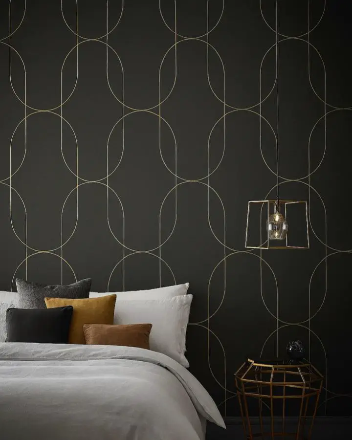 Dark geometric circle wallpaper from @shoppehavn. Overlapping gold circles on charcoal background with brass accents.