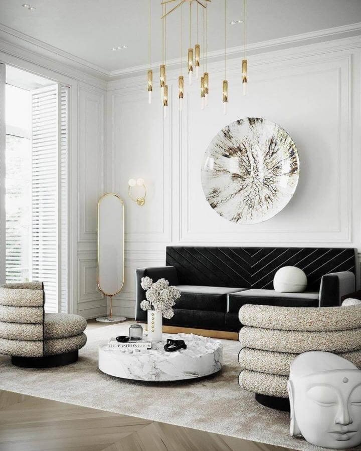 Black velvet sofa and boucle chairs with marble coffee table and gold accents from @moniquehepburn.ch. Cozy modern monochrome living space.