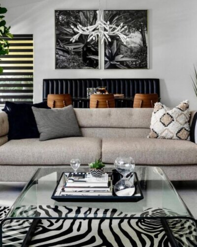 Zebra print rug in modern living room by @designvisionstudio with glass table and neutral sofa creating stylish monochrome vibes