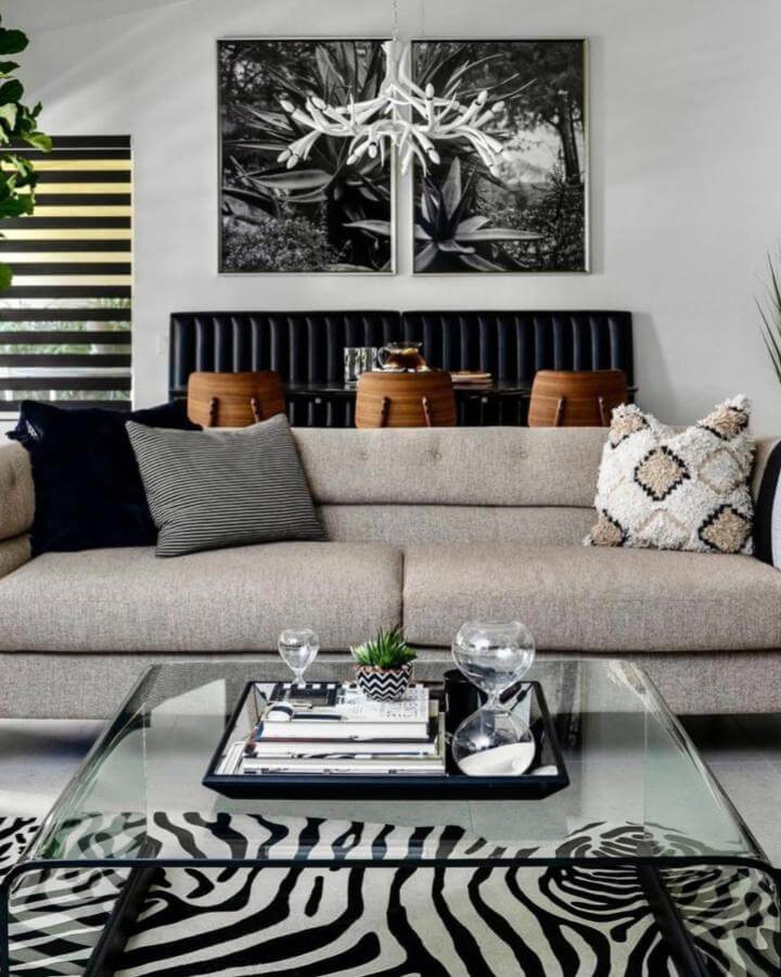 Zebra print rug in modern living room by @designvisionstudio with glass table and neutral sofa creating stylish monochrome vibes