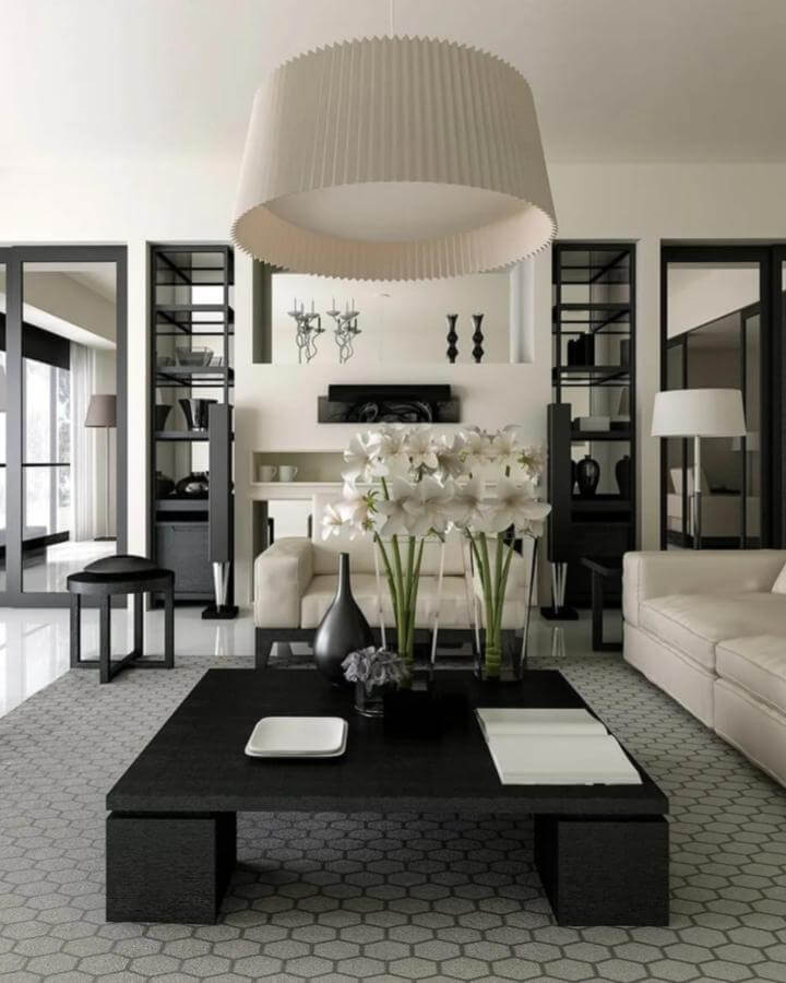 Black and white modern living room with hex tile floor, bold black coffee table, white sofas, and pleated pendant lighting from Decorilla.
