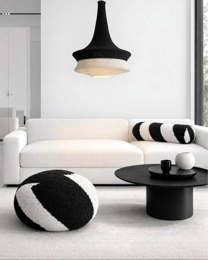 Black and white textured knit pouf and pillow in modern living room from @loopaconcept.pl with striking cozy vibes as black and white living room ideas