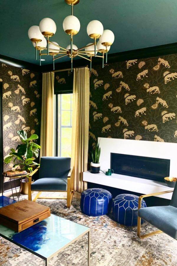 Luxurious lighting complements lush jungle decor, highlighting black & gold living room ideas.