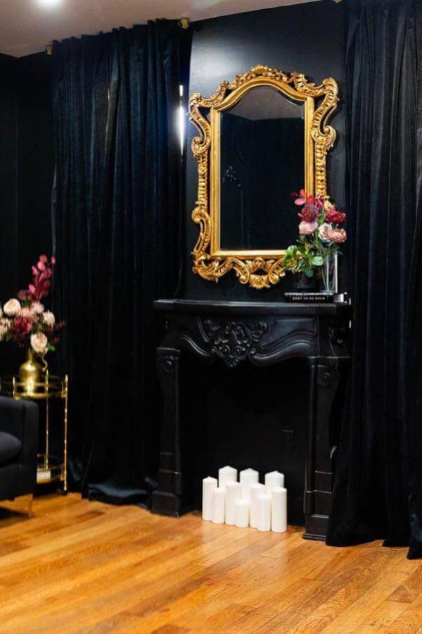 Mirror's golden frame complements black & gold living room ideas.