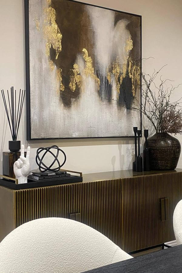 Artistic gold accents elevate modern vibe; black & gold living room ideas.