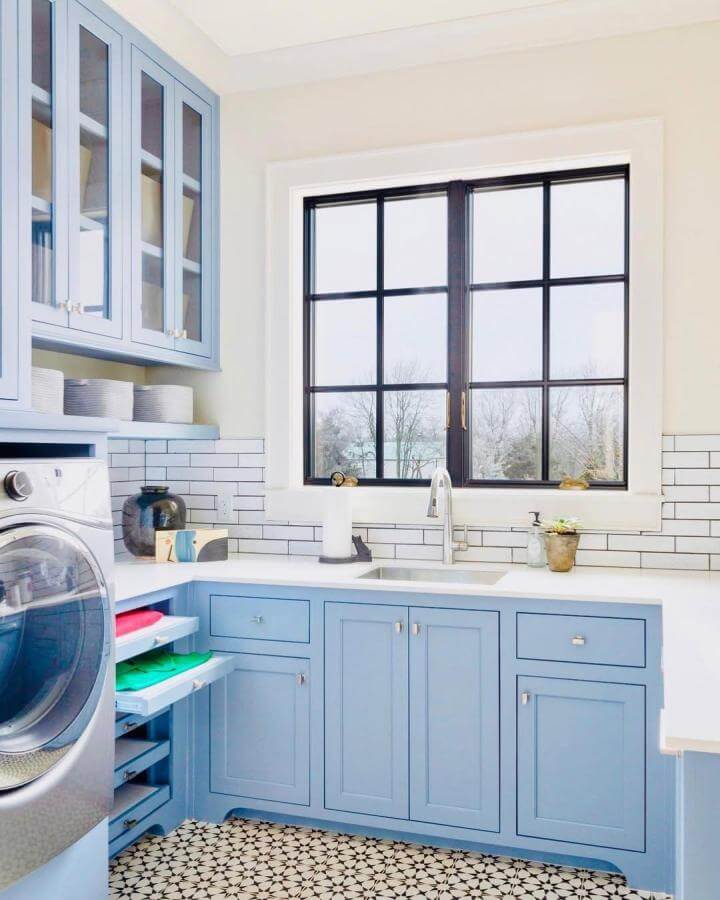Light blue shaker cabinets laundry room from @bethhallphotography. Fresh subway tile and patterned floor add crisp style.
