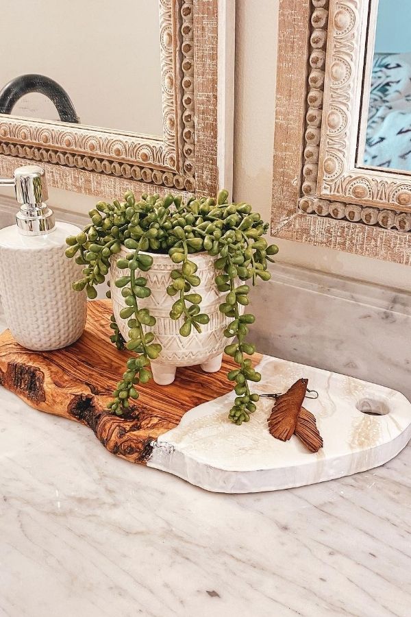 Boho bathroom ideas: Ornate wooden mirror frame complements cozy ambiance.