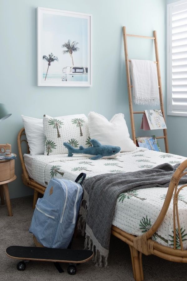 Coastal-themed bedroom featuring rattan bed frame and nautical decor.