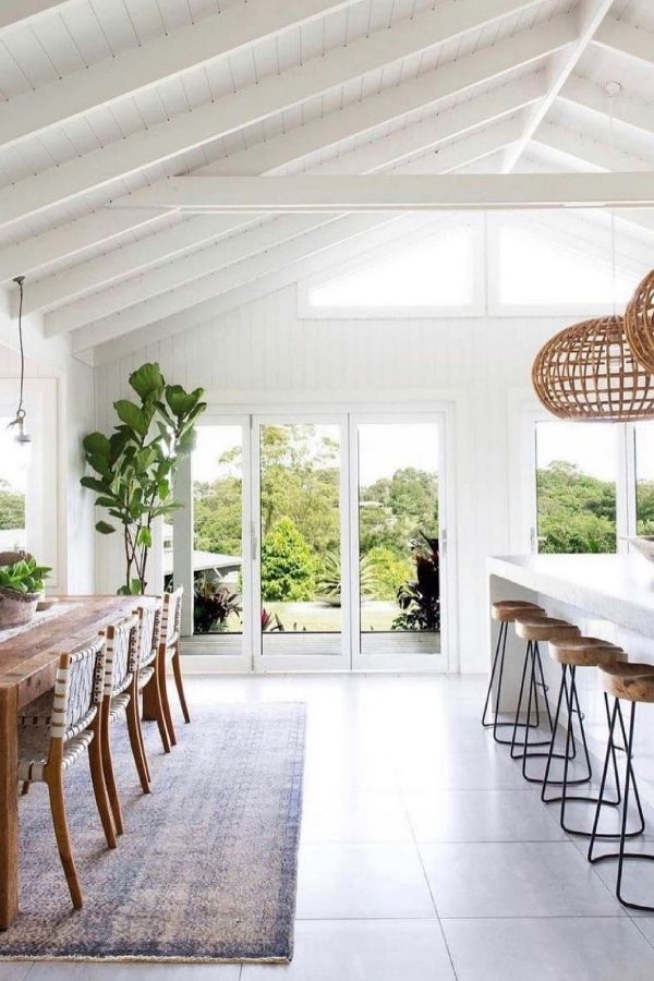 Open coastal kitchen features rattan lighting and seaside-inspired decor.