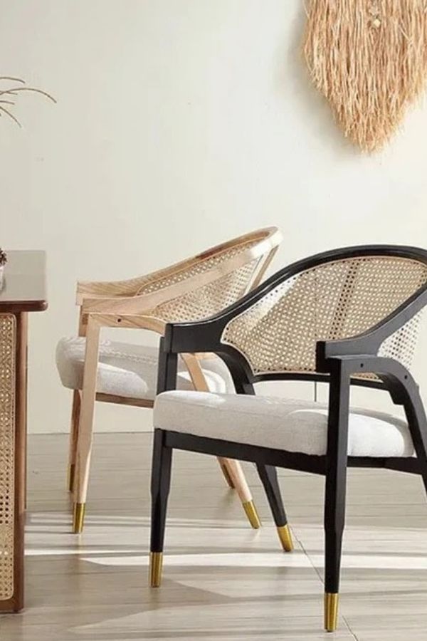 Wicker chairs with golden-tipped legs, perfect for boho furniture ideas.