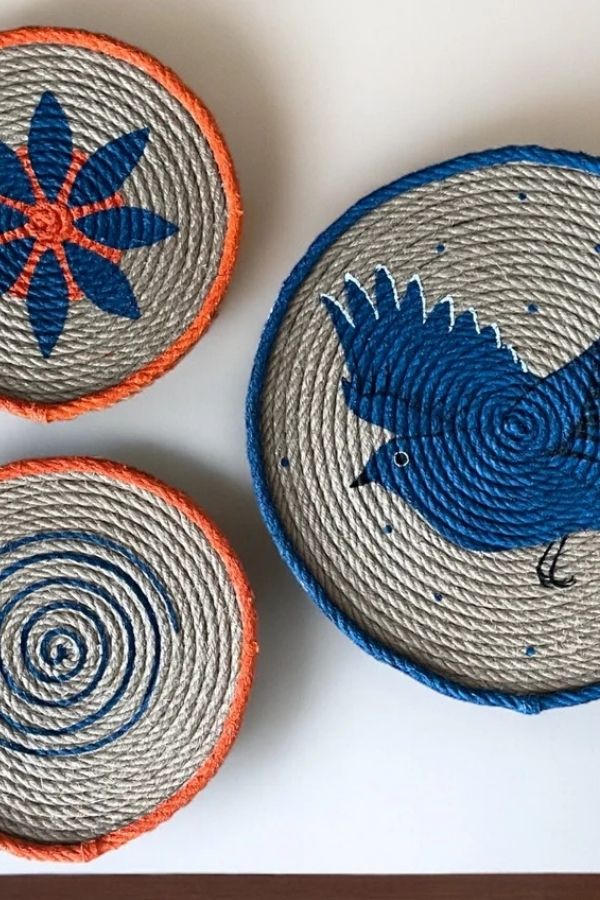 Colorful handwoven decorative rope baskets arranged on a wooden surface.