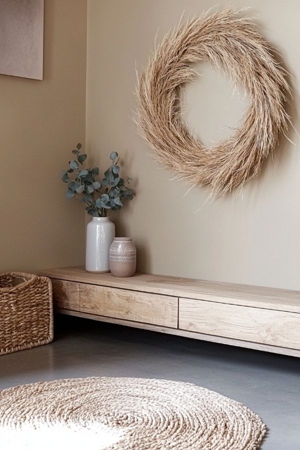 A rustic wreath hangs on a simple, neutral-toned wall.