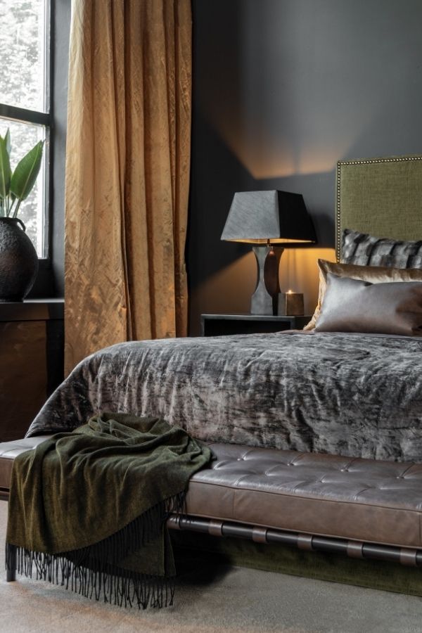 Luxurious bedroom featuring velvet accents, leather furnishings, and elegant decor.