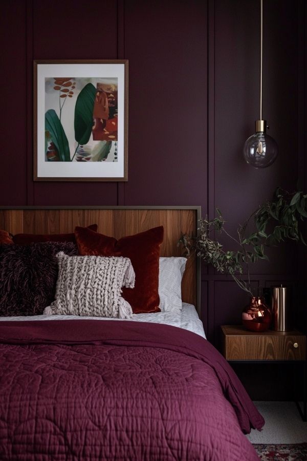 Cozy bedroom featuring burgundy accent wall with soft lighting.