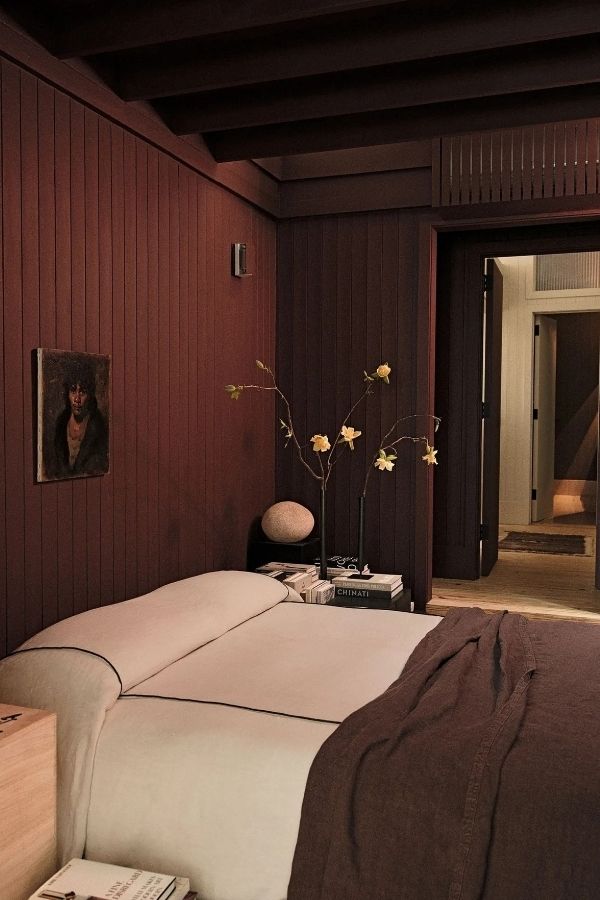 Minimalist bedroom featuring sleek burgundy paneling and simple, elegant decor.