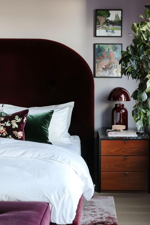 Modern bedroom featuring a luxurious burgundy headboard and elegant decor.