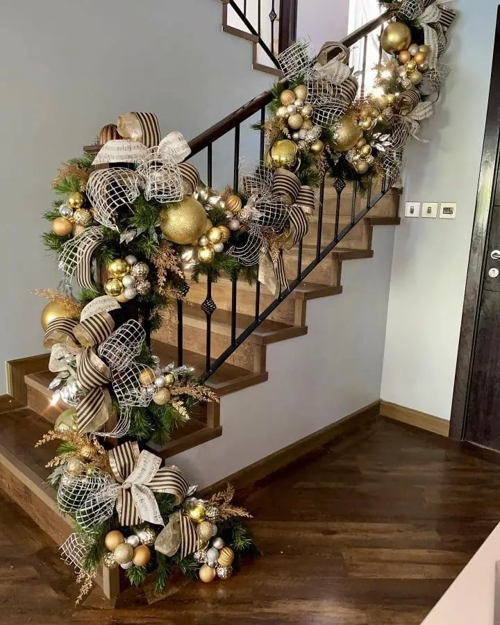 Gold and black ribbon staircase garland from @dalucydesign with oversized bows and ornament clusters
