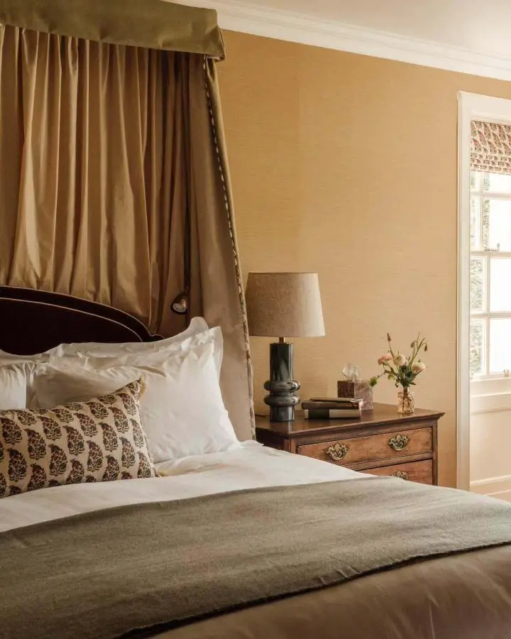 Olive-green canopy bed from @anboise_official. Dark wooden frame with chain details and neutral bedding setup.