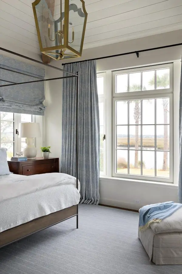 Flowing blue linen curtains from @katherineconnelldesign. Layered with matching roman shades for coastal bedroom style.
