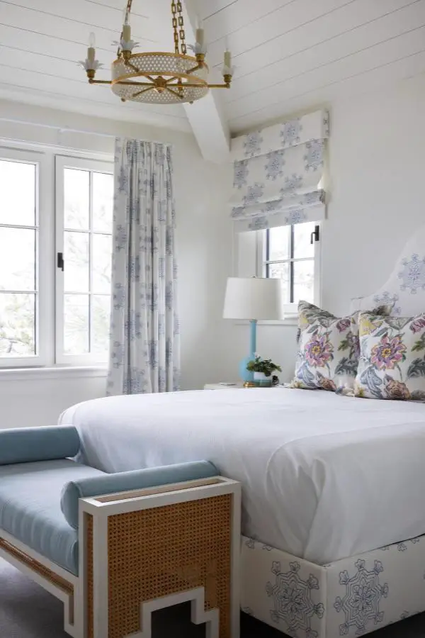 Floral patterned pillows from @katherineconnelldesign featuring coastal bedroom ideas with purple and yellow blooms on white bedding.