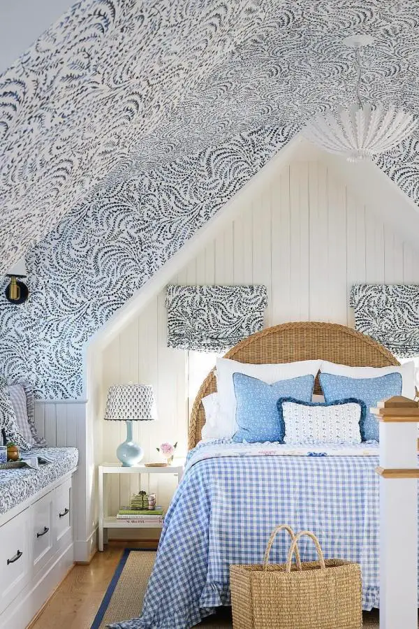 Navy wave-patterned wallpaper bedroom from @kipdawkinsphoto. Wicker headboard with blue gingham bedding and coastal decor accessories.