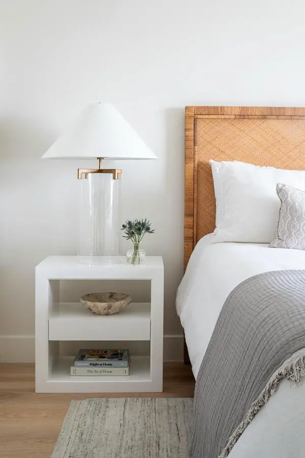Natural rattan headboard from @lolainteriors with white bedding and modern nightstand styling.