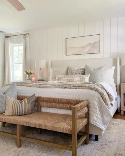 Woven rush bench from @sherricalnanhome. Natural texture piece positioned at foot of neutral coastal bed.