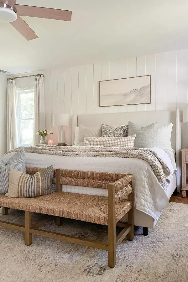 Woven rush bench from @sherricalnanhome. Natural texture piece positioned at foot of neutral coastal bed.