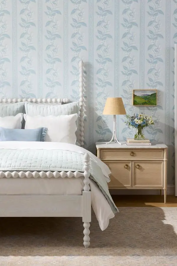 Pale blue botanical wallpaper bedroom from @serenaandlily showcasing coastal bedroom ideas with white bedding and natural wood nightstand.