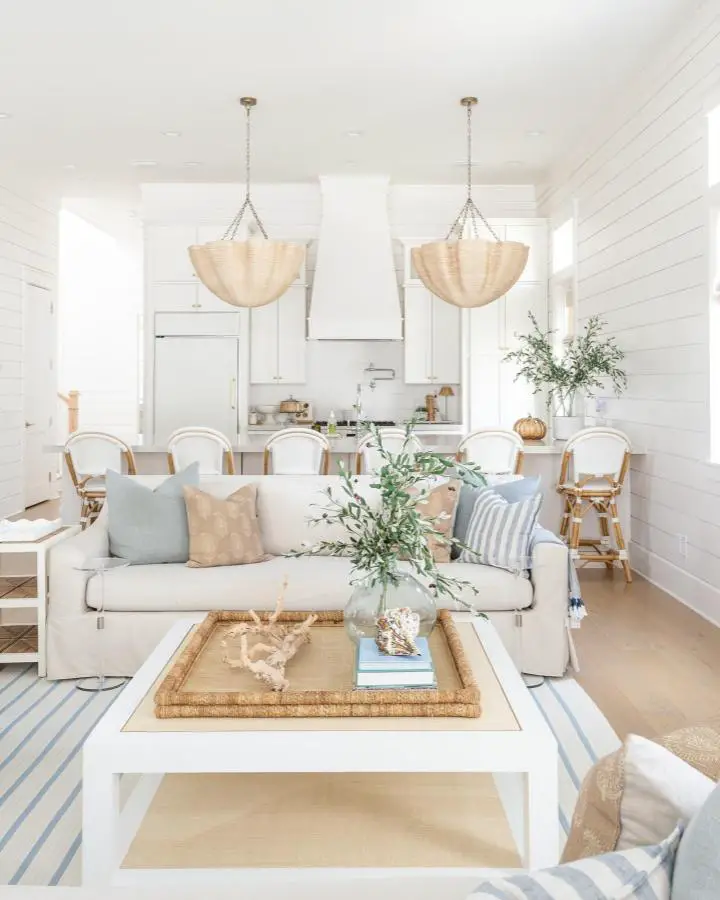Natural woven pendant lights from @lifeonvirginiastreet hanging over white dining table in bright open living space.