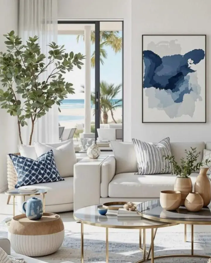 Modern abstract artwork from @claudiacarolina_interiors featuring flowing blue and gray watercolor patterns above neutral sectional sofa.