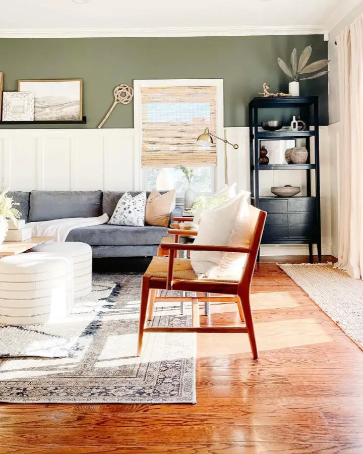Sage green accent wall with gray sectional from @southshorecolonial. Natural wood floors and coastal decor elements.