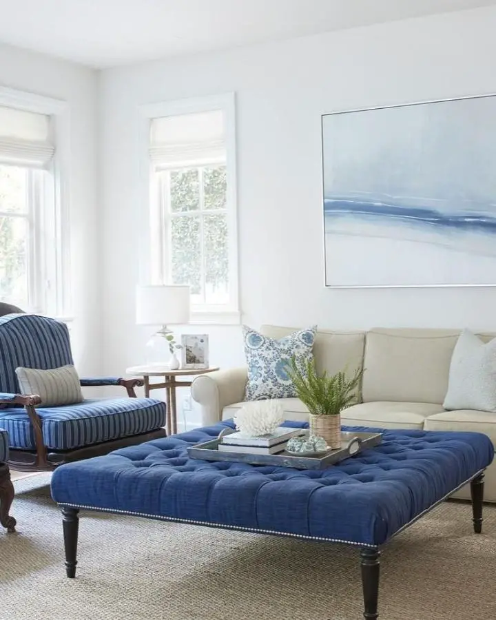 Navy tufted ottoman from @jharkavyinteriors showcasing coastal living room ideas with button-tufted upholstery and silver nailhead trim.