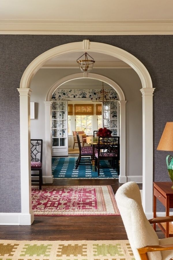 Colonial living room featuring arched doorway, elegant furniture, and decor.