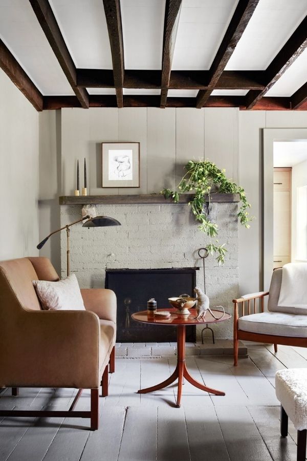 Cozy rustic Colonial living room featuring exposed wooden ceiling beams.