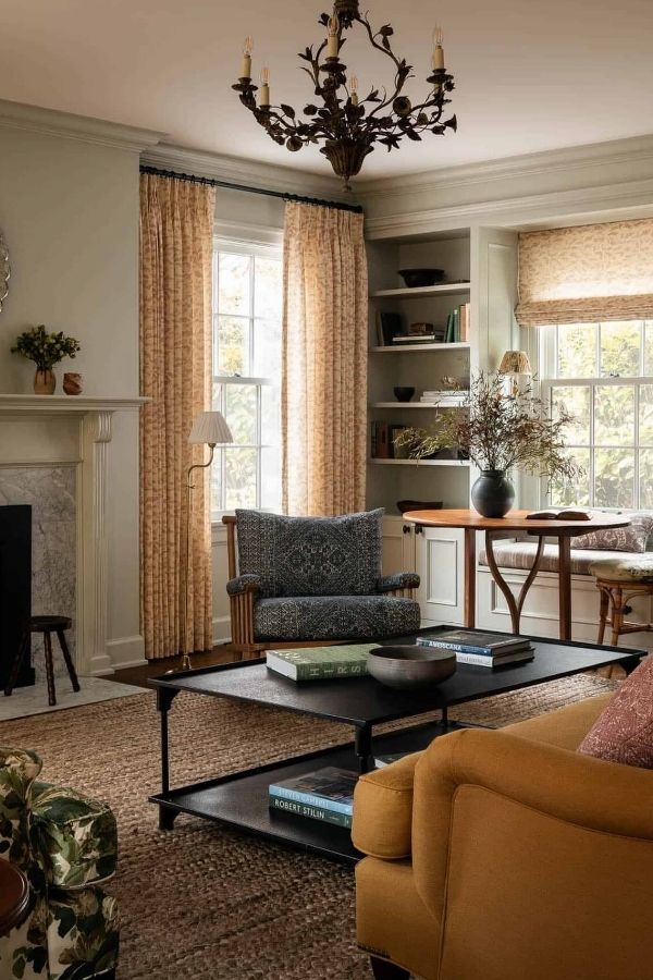 A colonial living room featuring elegant chandelier and classic furnishings.