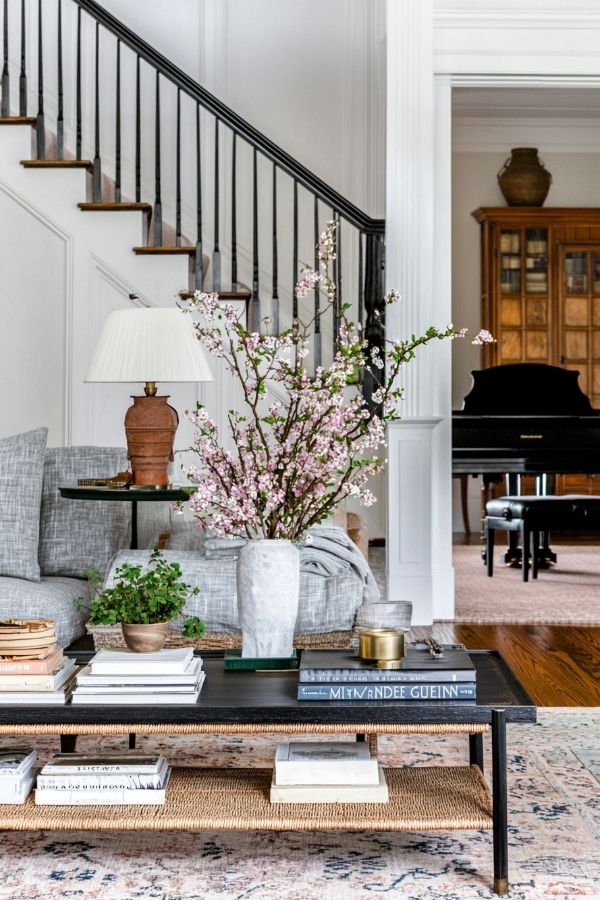 Spacious, well-lit colonial living room with elegant staircase and furniture.