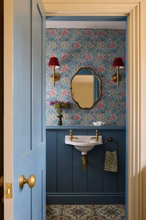 Whimsical blooms and vintage brass accents on cozy seating from @uns.hobbs_interiors. Bright colorful cottagecore interior charm.