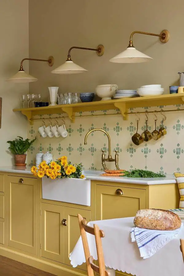 Charming yellow cabinets with open shelves from @uns.hobbs_interiors. Cozy storage in vibrant cottage style.