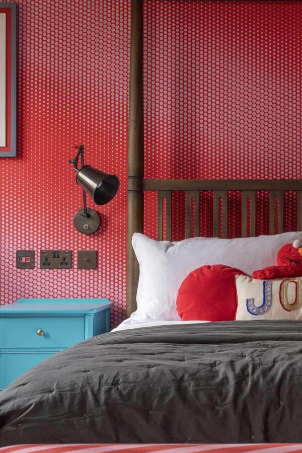 Vibrant red wallpaper from @titchmarshandgoodwin enlivens a teen's bedroom, inspiring youthful energy and creativity.