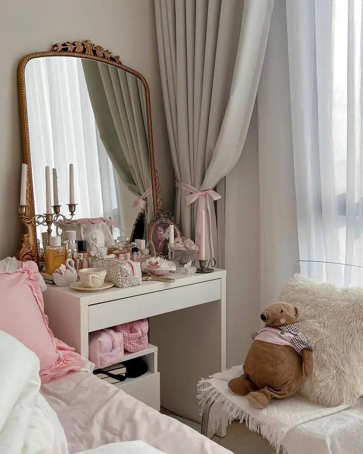 Ornate gold baroque mirror from @ramboishappy. Vintage vanity setup with pink ribbons and glass perfume bottles displayed elegantly.