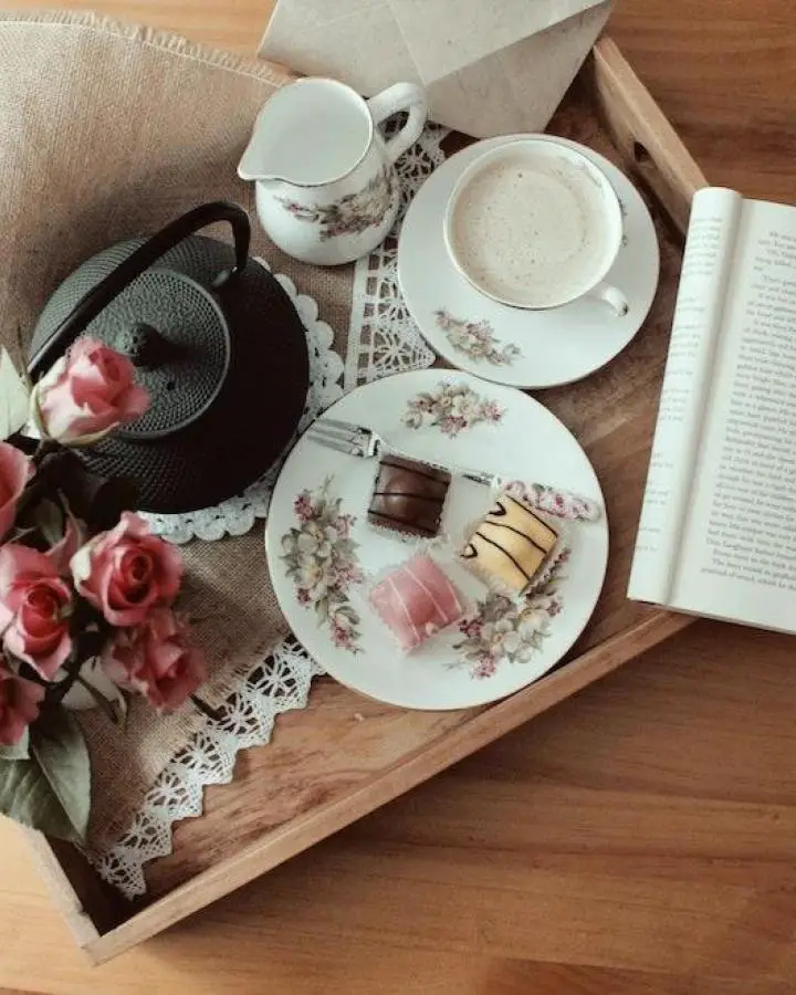Vintage floral tea set arranged on wooden tray perfect for coquette bedroom decor ideas with pink roses and lace details.
