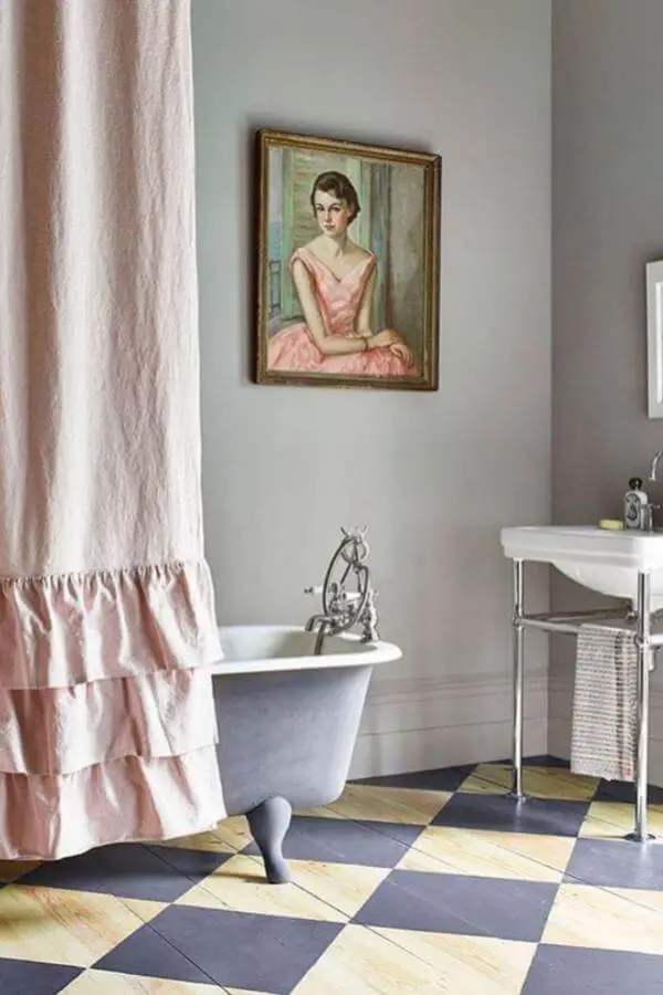 Framed vintage portrait and clawfoot tub showcasing cottagecore bathroom ideas from @anniesloanhome. Romantic artwork above elegant bathing space.