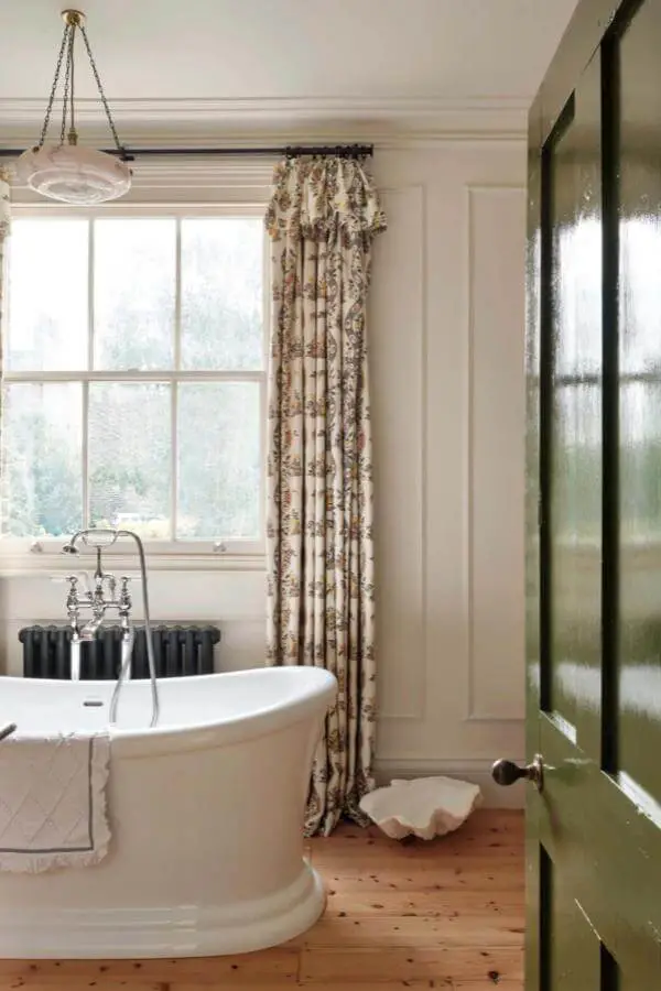Cream floral curtains in bathroom from @pandorasykes. Features ruffled valance and floor-length botanical print fabric.