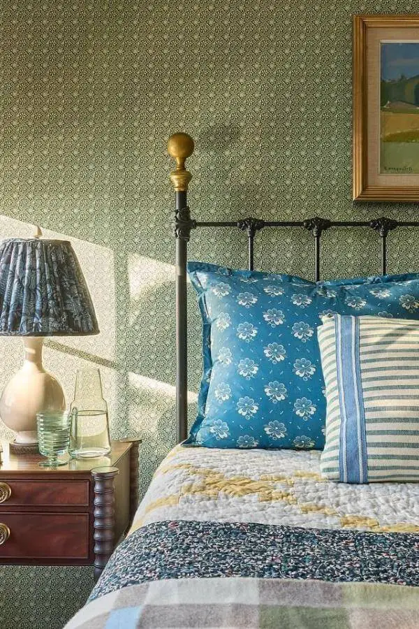 soft floral-patterned bedding and antique iron bedframe from @katierosenfeld. Cozy cottagecore bedroom charm.