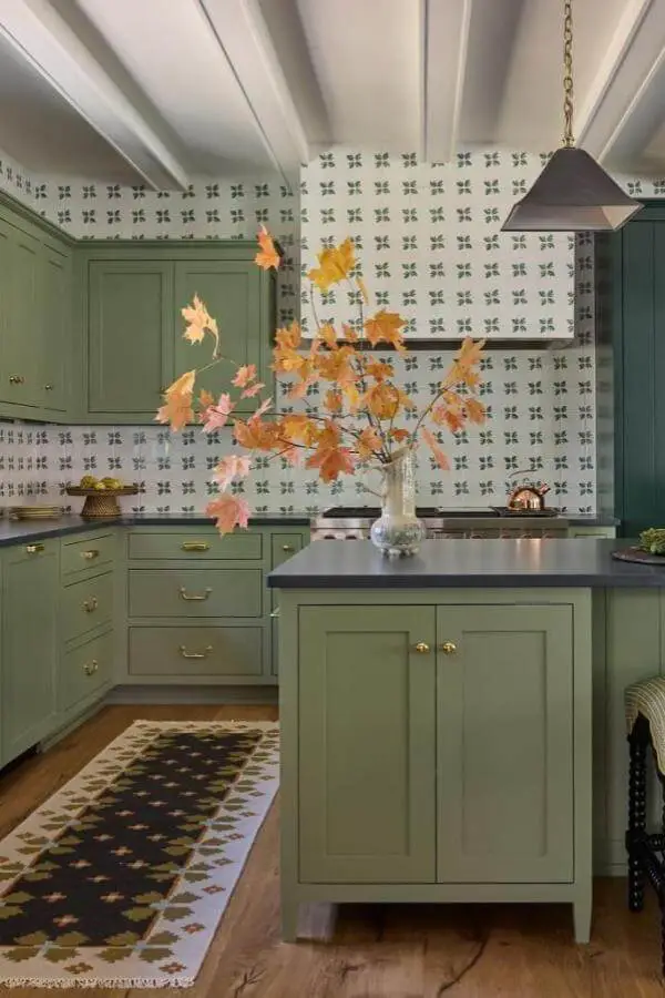 Sage green kitchen island from @katierosenfeld. Autumn branches and patterned wallpaper complete the cozy look.