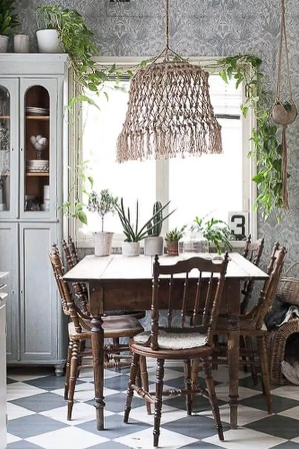 Natural woven pendant light from @dgsisustusmania. Macrame style fixture hangs over wooden dining table with plants.