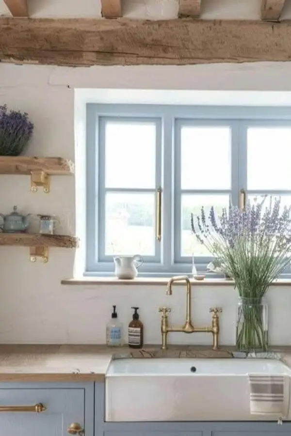 Pale blue kitchen sink area from @clementbrowne featuring cottagecore kitchen ideas with brass fixtures and lavender accents.